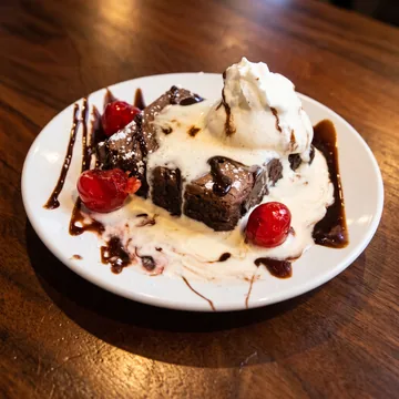 Chocolate brownie with ice cream and cherries