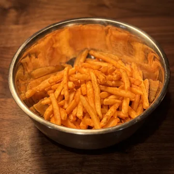 Seasoned French fries in a steel bowl