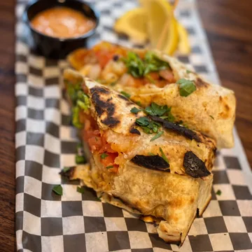 A grilled wrap cut in half with pico de gallo