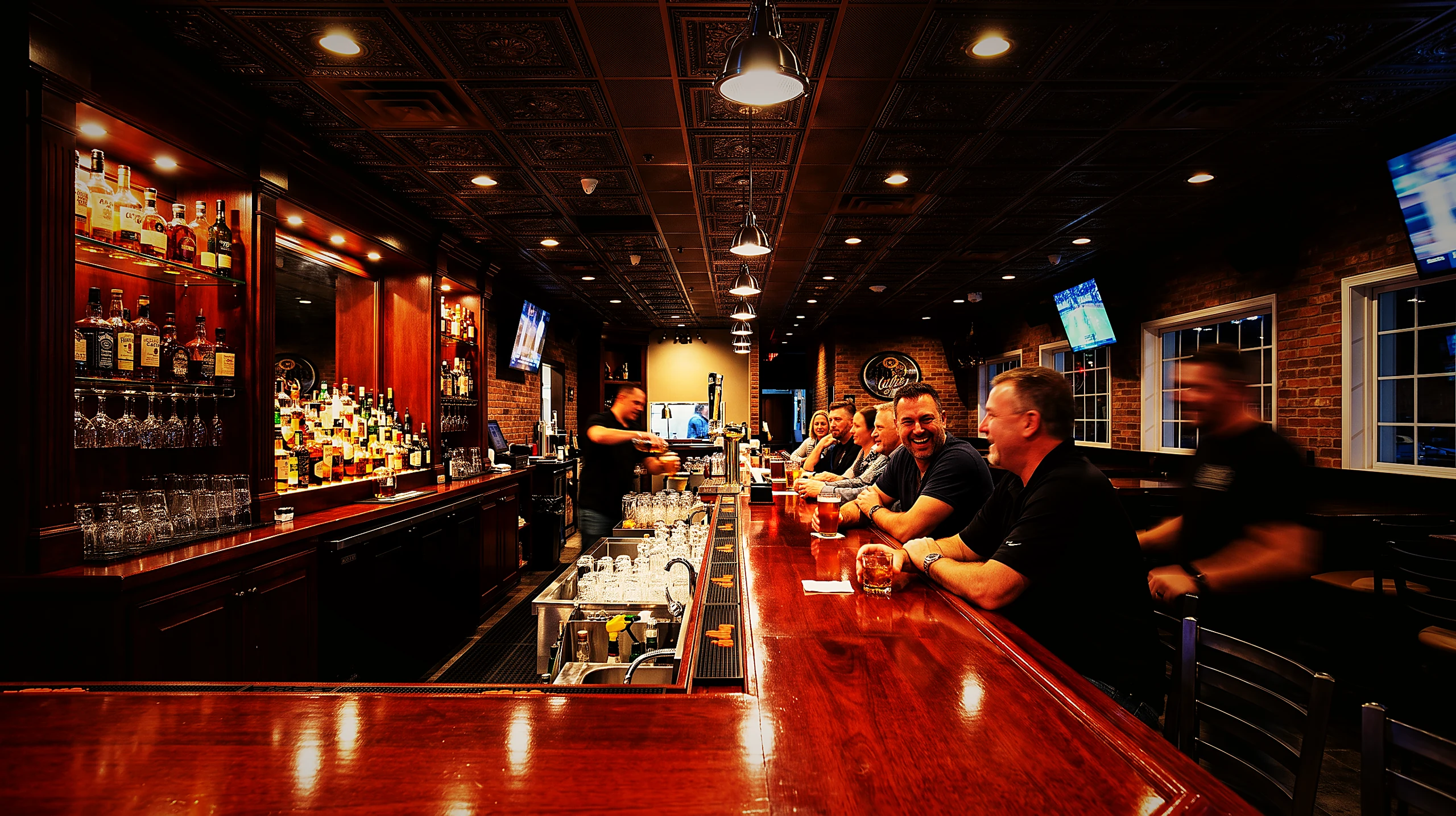 Guests at the 40-foot wood bar at Rush Hour